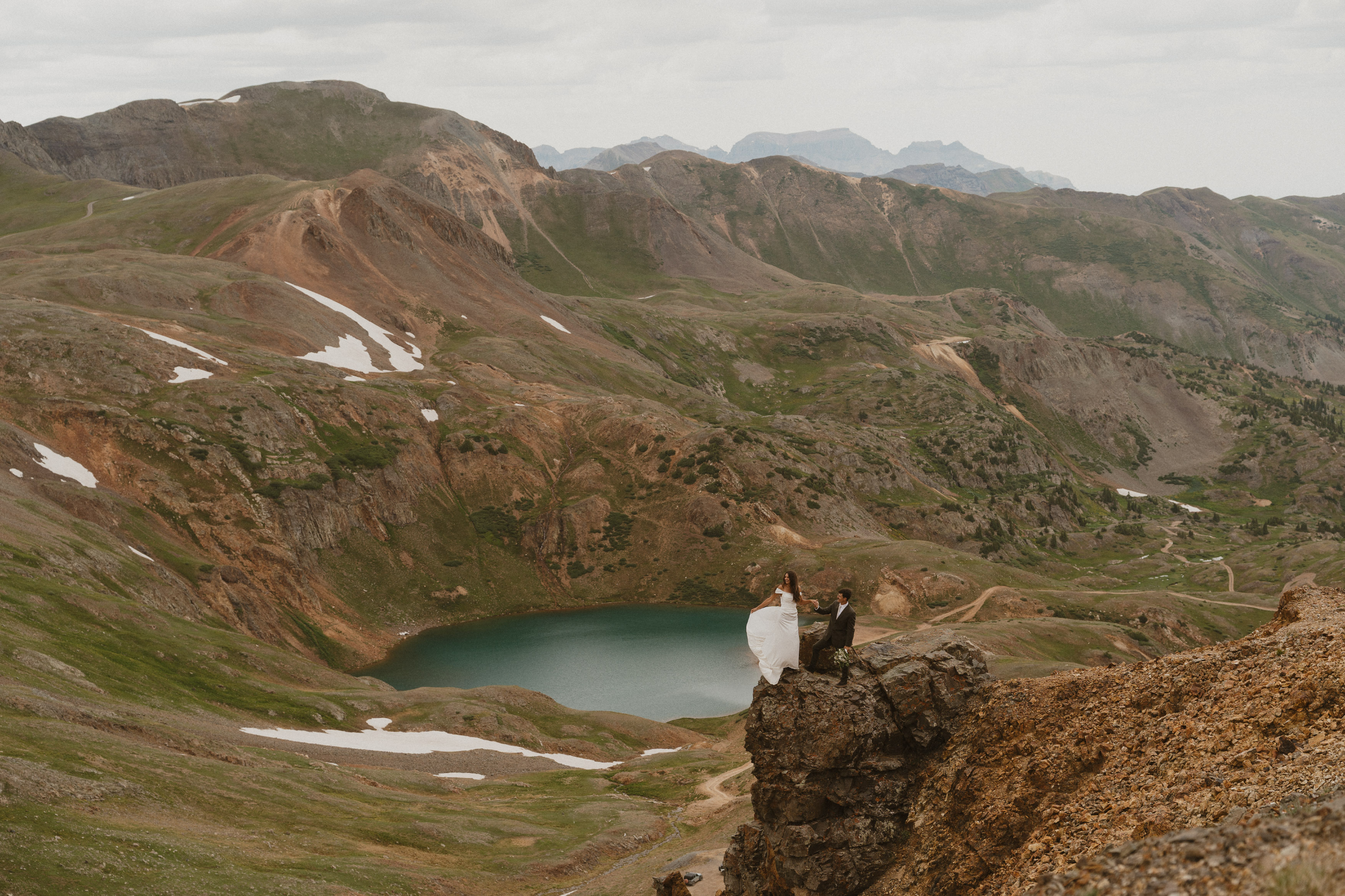 married couple standing on edge of cliff in Ouray Colorado