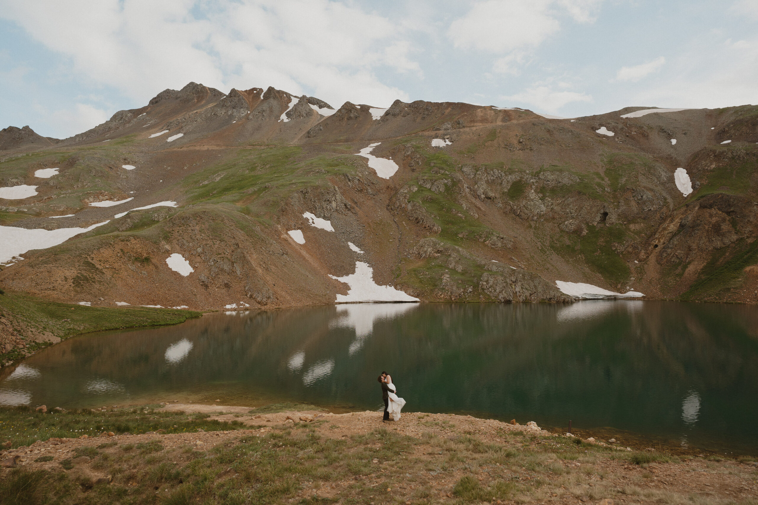 wedding standing by lake on their wedding day in ouray