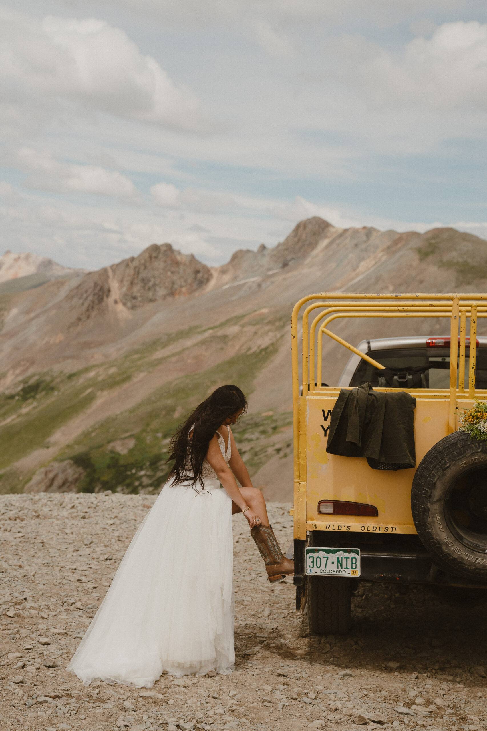 bride tying shoe on jeep in crested butte colorado