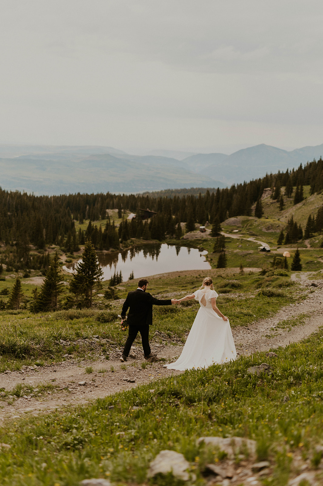 couple walking down path to alpine lake in telluride colorado