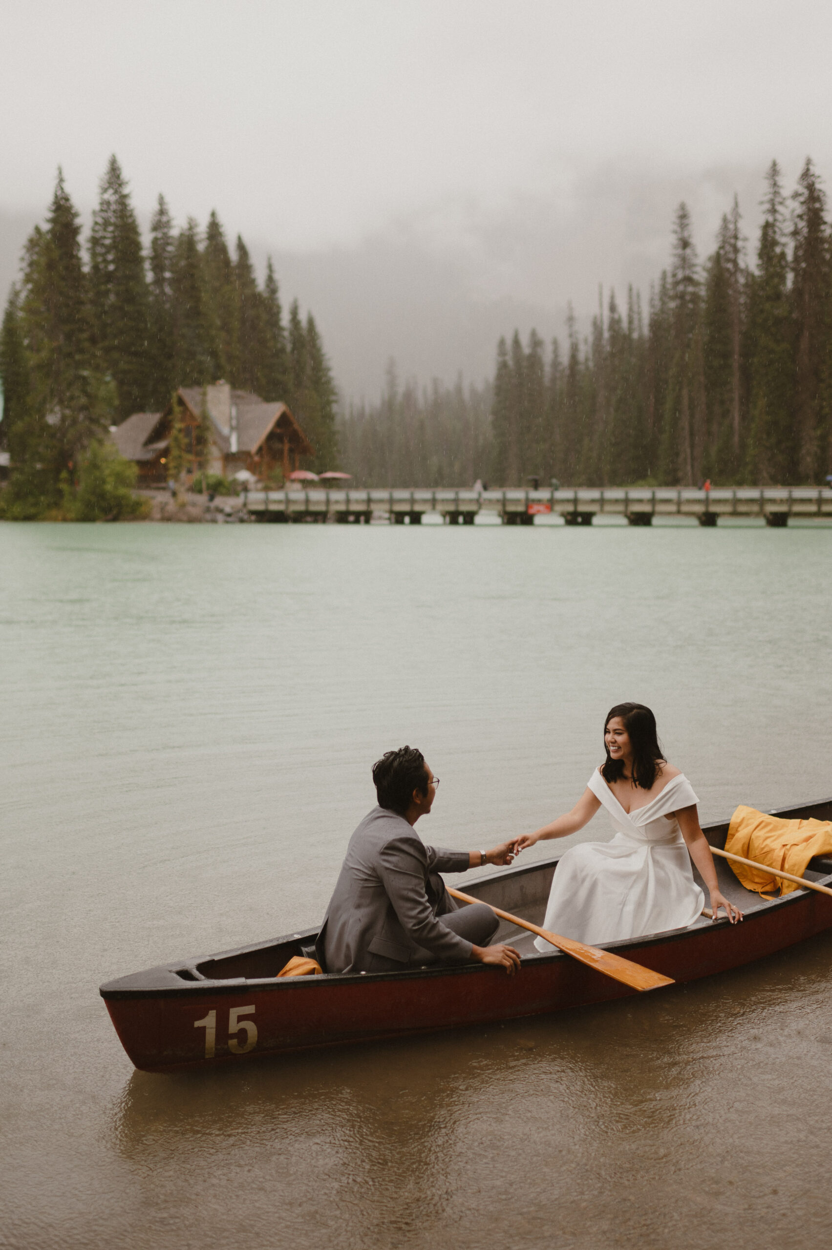 couple canoeing across alpine lake