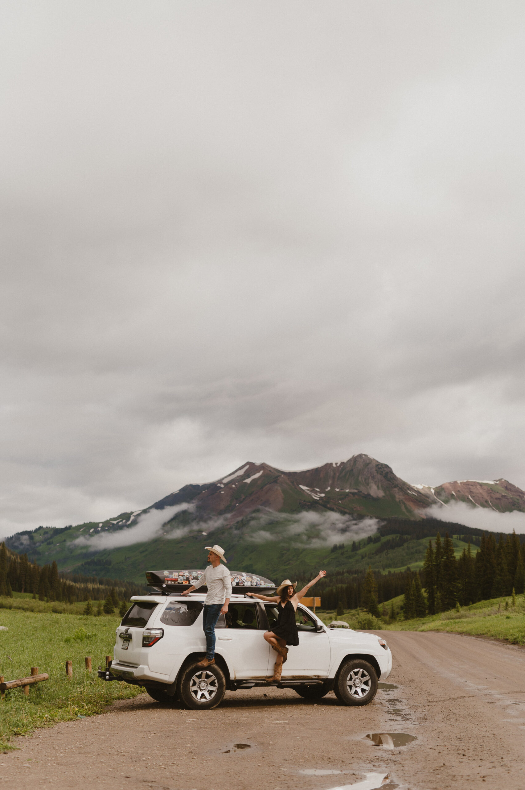 Couple standing on four runner in crested butte colorado with hands in the air