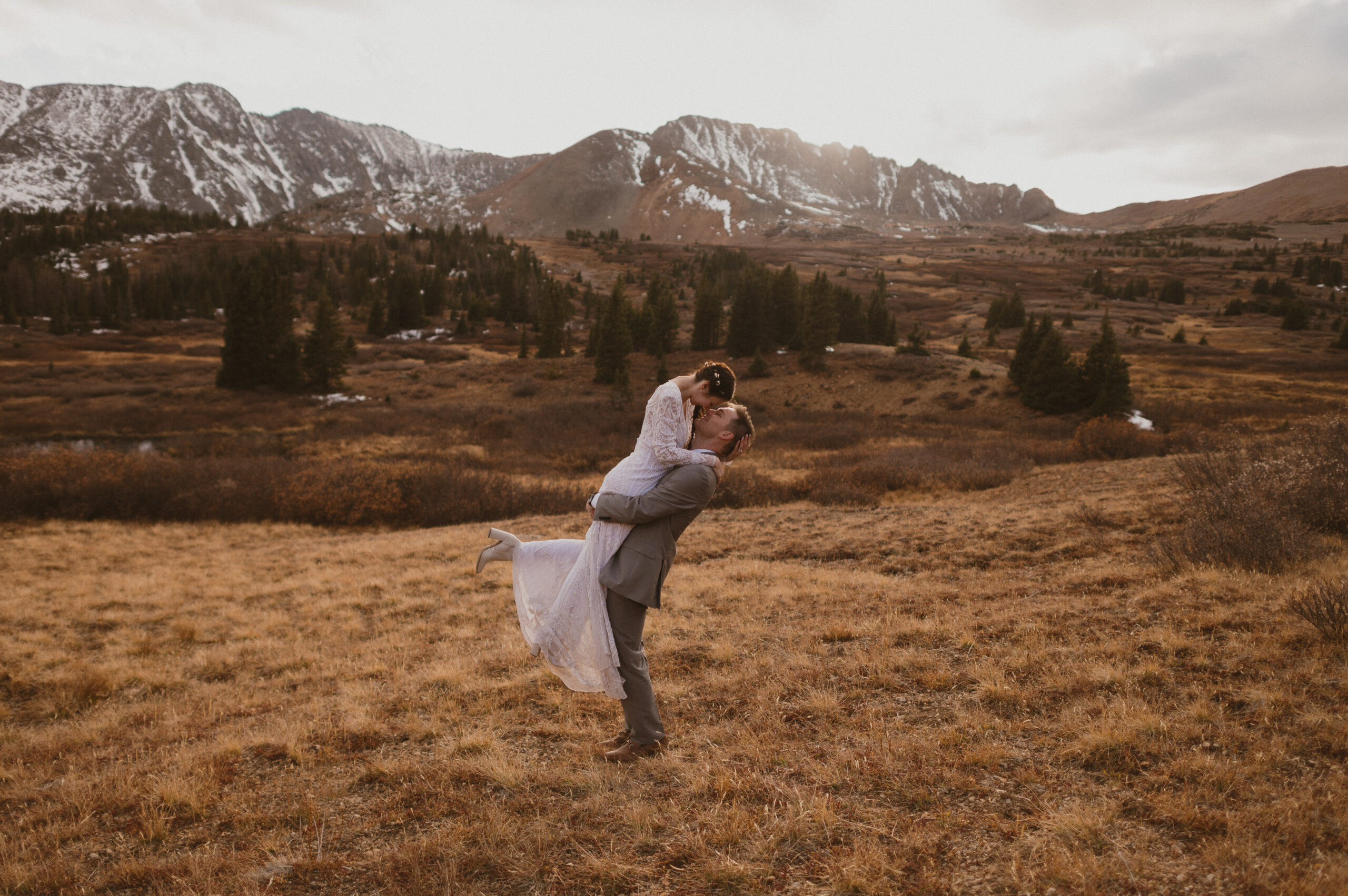 groom picking bride up and kissing her in colorado