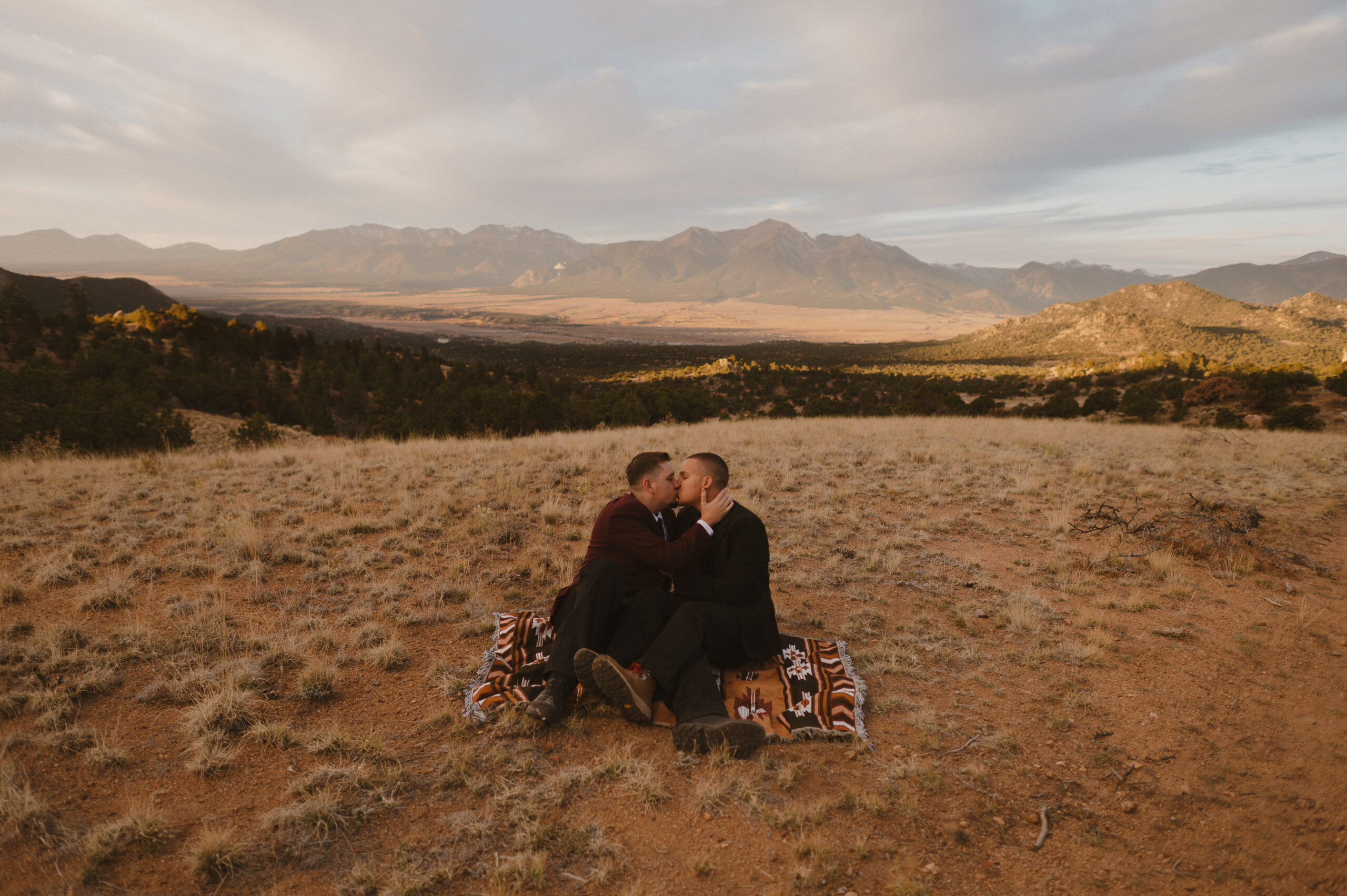 couple sitting on a blanket in the collegiate peaks kissing