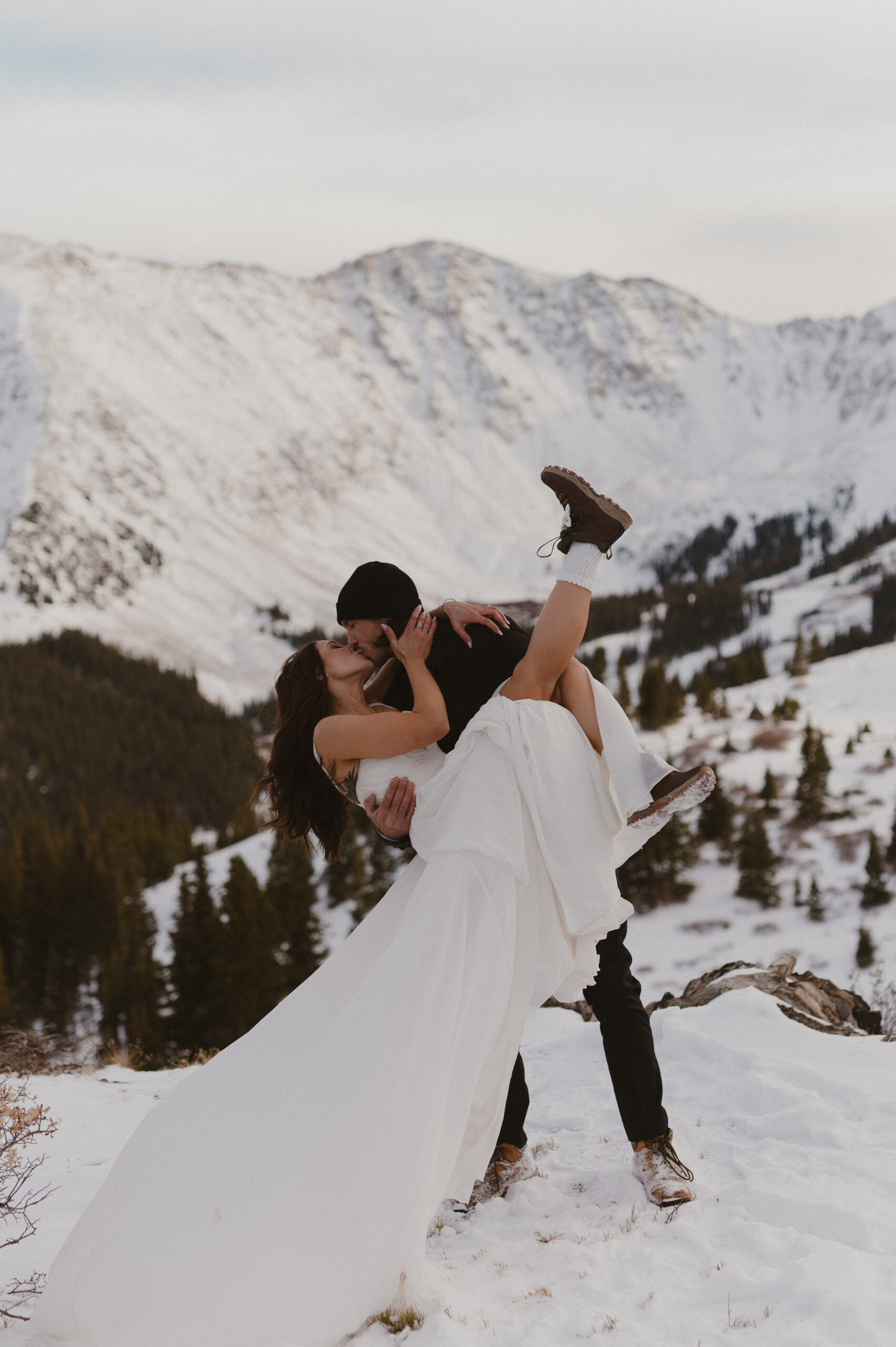 Wedding couple dipping for a kiss in Loveland Pass, Colorado