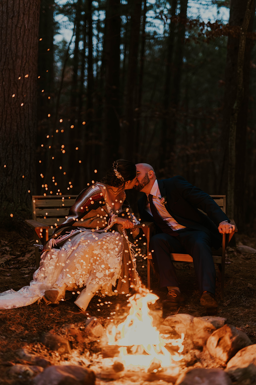 couple in blanket in front of campfire