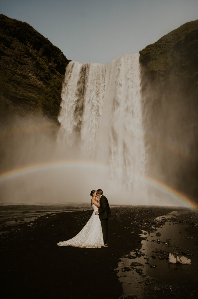 wedding couple under rainbow at skogafoss waterfall in iceland