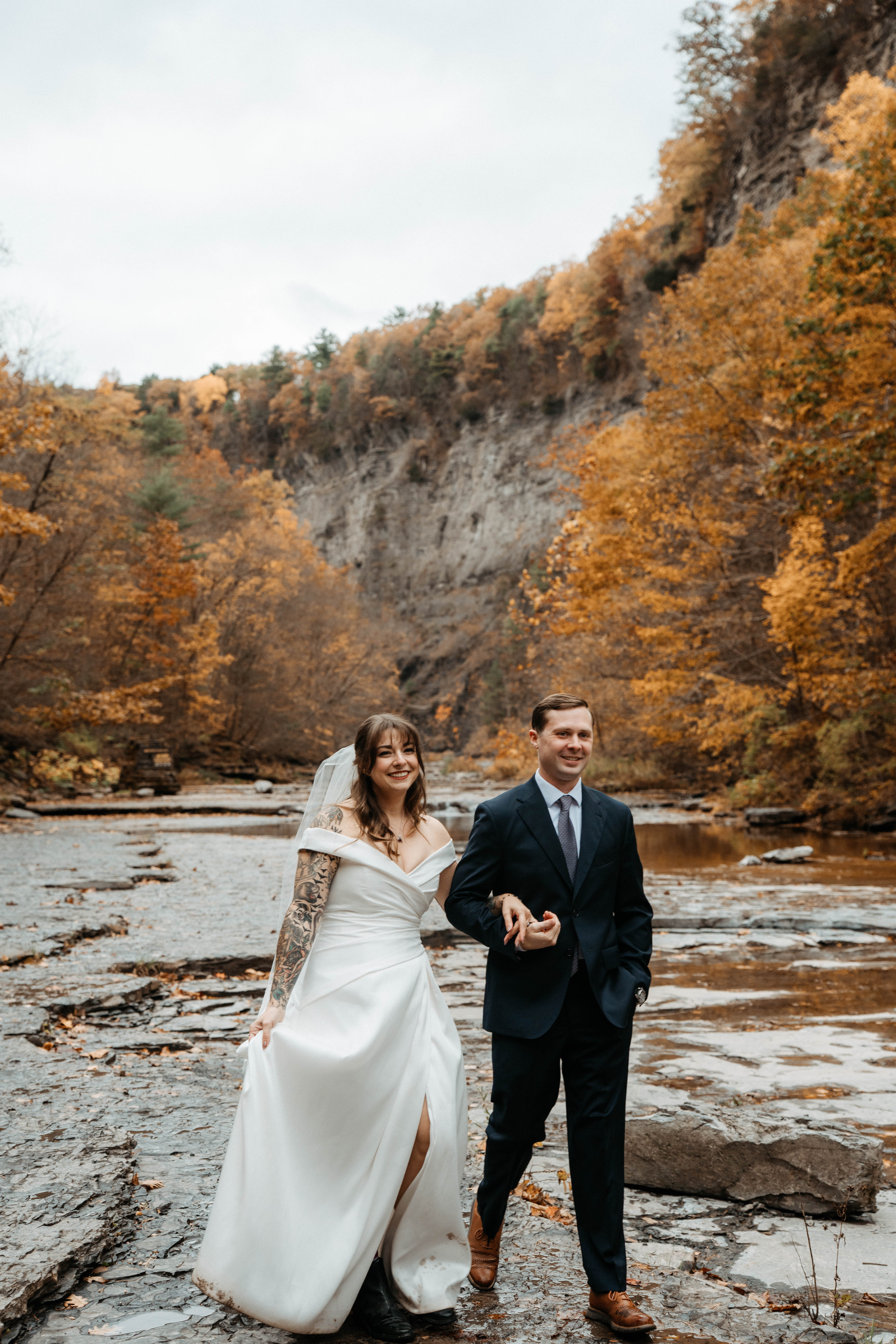 wedding couple walking through fall foliage in upstate new york
